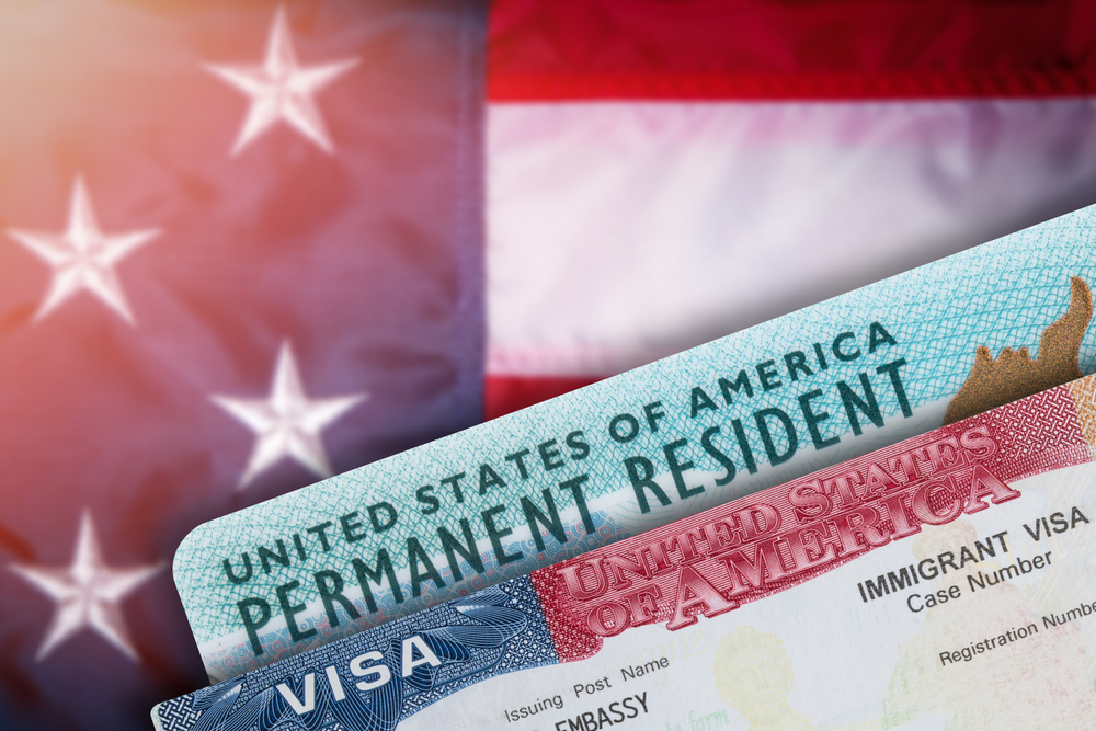 Green card paperwork and visa with american flag