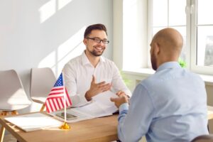 Immigration attorney at desk speaking with client