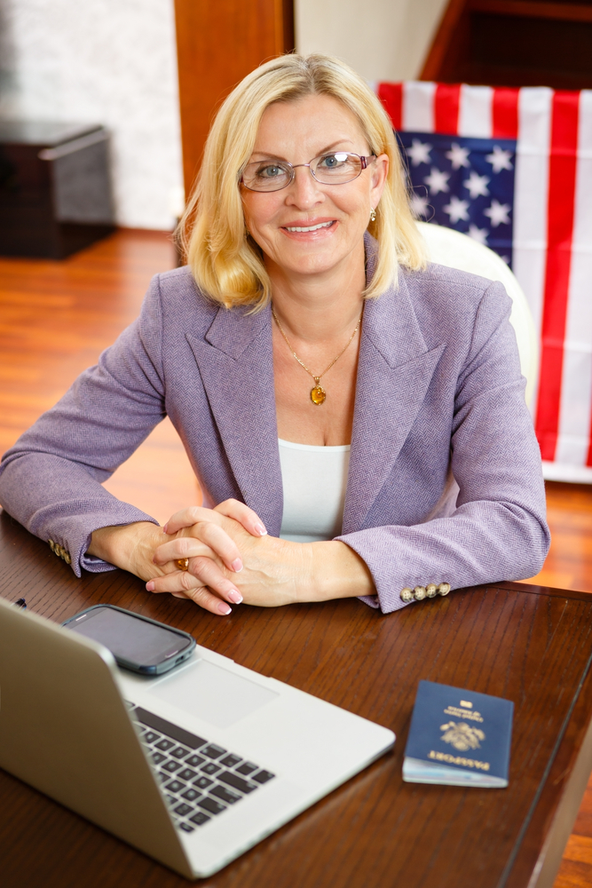 Female immigration attorney sitting at desk smiling