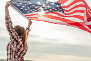 Woman flying American flag behind her for immigration post