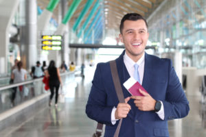 Foreign businessman applying for e2 visa holding passport in airport with briefcase