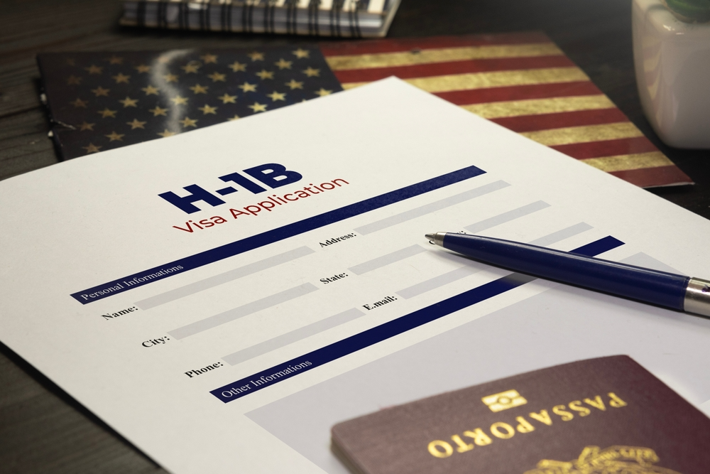 h-1b visa application with passport and USA flag on a San Diego immigration lawyer's desk