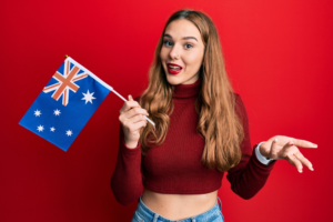 E-3 visa holder smiling and holding the Australian flag