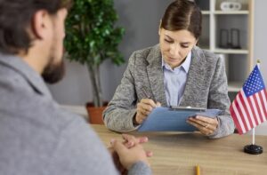 Applicant seated across desk during visa interview at U.S. embassy office