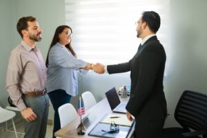 Couple meeting with legal advisor at desk, reviewing documents during consultation